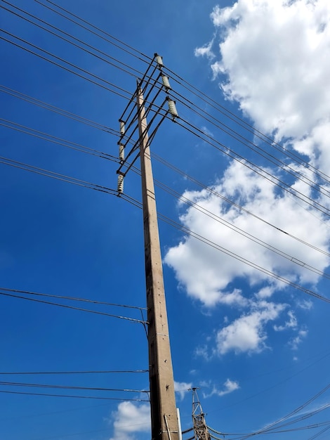 Hochspannungsleitungen auf Wolken im blauen Himmel