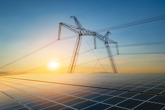 Hochspannungsmasten mit Stromleitungen, die Strom aus Photovoltaik übertragen, werden bei Sonnenaufgang verkauft. Erstellung eines nachhaltigen Energiekonzepts.