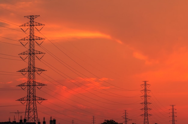 Hochspannungsstrommast und Übertragungsleitungen am Abend. Strommasten bei Sonnenuntergang. Kraft und Energie. Energieeinsparung. Hochspannungsgitterturm mit Drahtseil an der Verteilerstation.