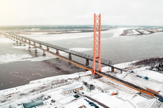 Hochstraßenbrücke über den Fluss und die Eisenbahnbrücke. Blick auf den eiskalten Fluss mit Eis.