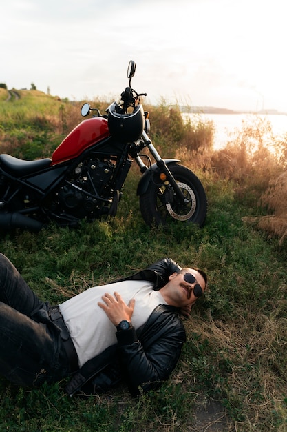 Foto hochwinkel-mann mit motorrad im freien