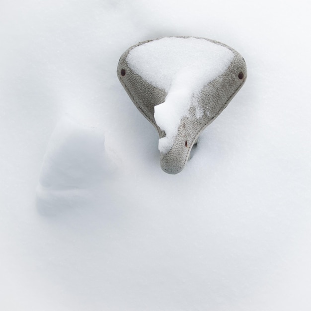 Hochwinkelansicht auf einen schneebedeckten Fahrradsitz