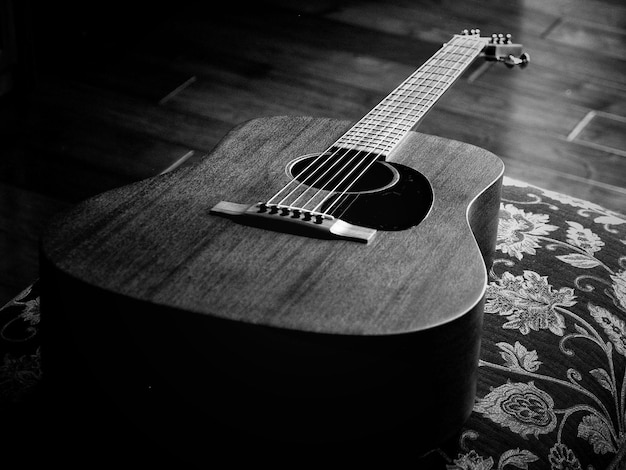 Hochwinkelansicht der akustischen Gitarre auf dem Kissen zu Hause
