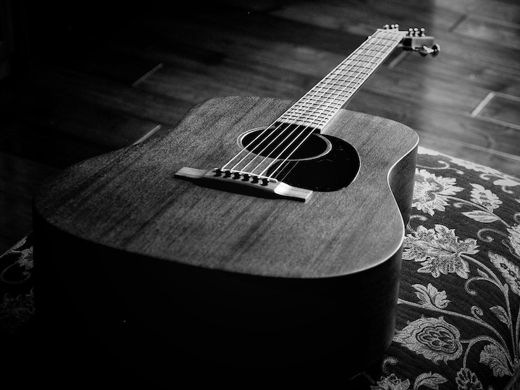 Foto hochwinkelansicht der akustischen gitarre auf dem kissen zu hause