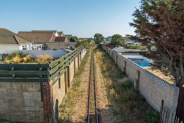 Foto hochwinkelansicht der alten eisenbahnstrecke inmitten von wänden vor klarem himmel