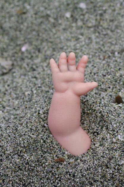 Foto hochwinkelansicht der hand der puppe auf dem sand am strand