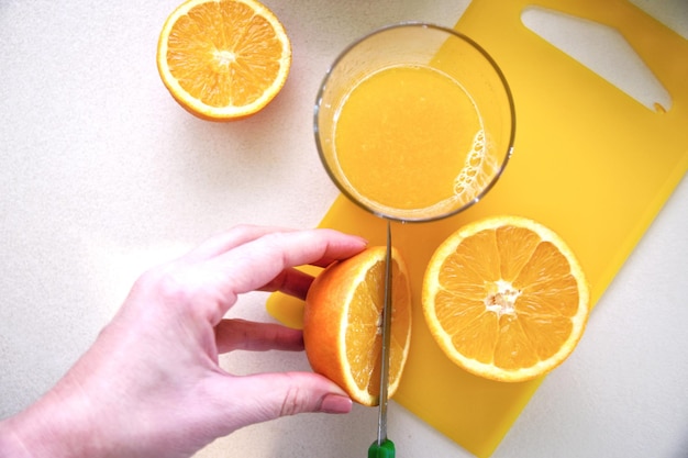 Foto hochwinkelansicht der hand, die orangensaft hält