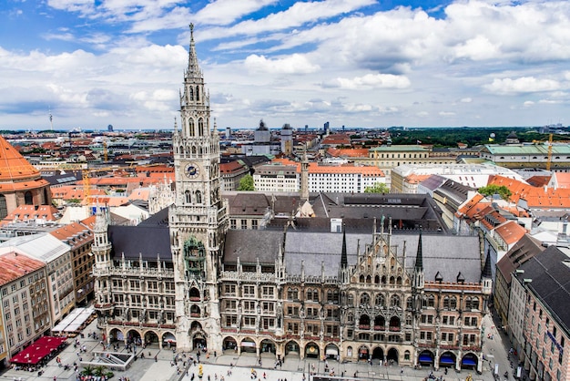 Hochwinkelansicht der Münchner Kathedrale inmitten von Gebäuden gegen den bewölkten Himmel in der Stadt
