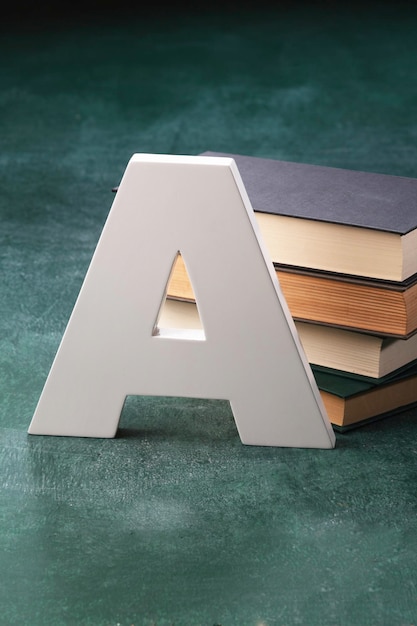 Foto hochwinkelansicht des buchstaben a mit büchern auf dem tisch