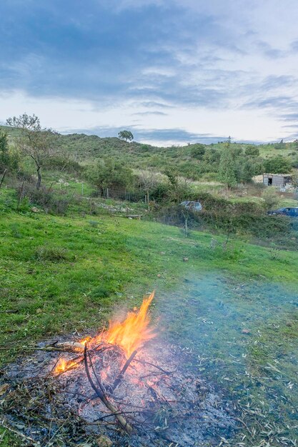 Hochwinkelansicht des Feuers auf dem grasbewachsenen Feld gegen den Himmel