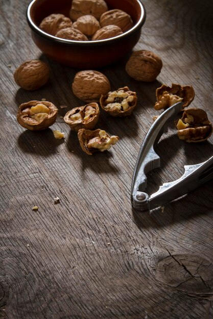 Foto hochwinkelansicht des nussknackers mit walnüssen auf einem holztisch