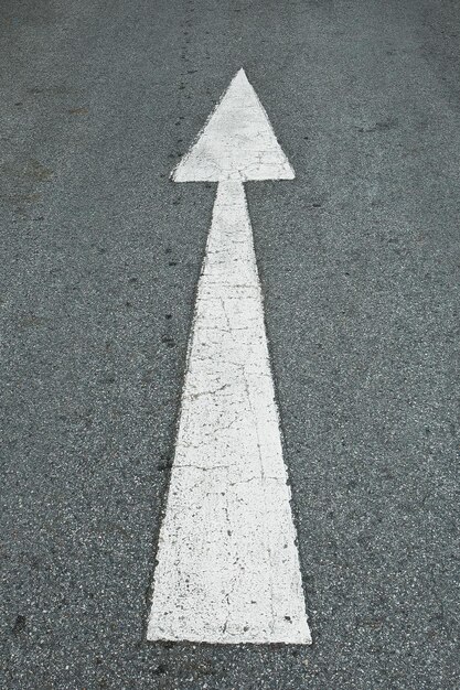 Hochwinkelansicht des Pfeilsymbols auf der Straße