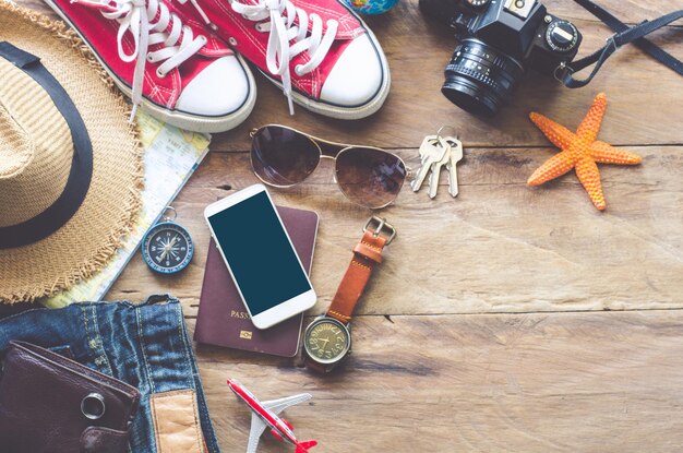 Foto hochwinkelansicht des tagebuchs und des reiseaccessoires mit technologie auf dem tisch