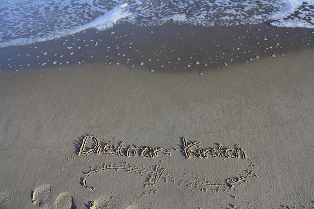 Hochwinkelansicht des Textes am Sandstrand