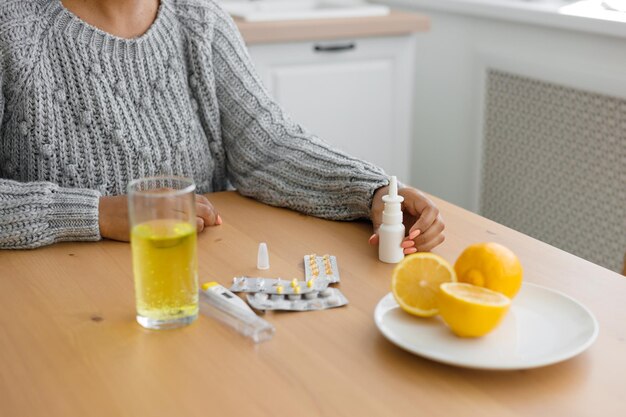 Hochwinkelansicht einer Frau mit Pillen auf dem Tisch