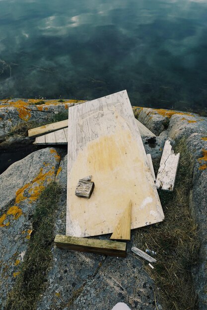 Foto hochwinkelansicht einer holzplatte auf einem felsen am strand