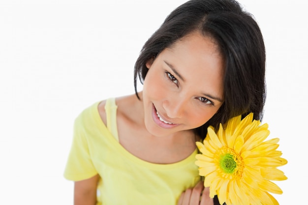 Hochwinkelansicht einer Latinofrau, die einen Gerbera hält