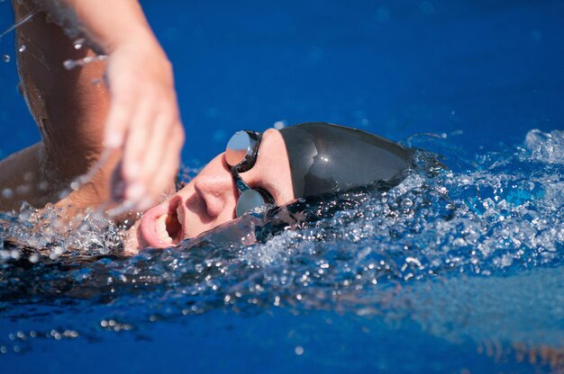 Hochwinkelansicht einer mittleren erwachsenen Frau, die im Pool schwimmt