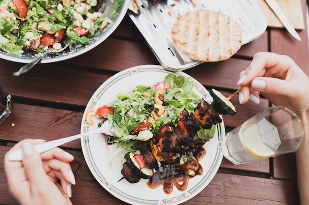 Foto hochwinkelansicht einer person, die essen auf dem tisch zubereitet