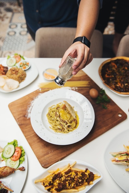 Hochwinkelansicht einer Person, die Essen auf dem Tisch zubereitet