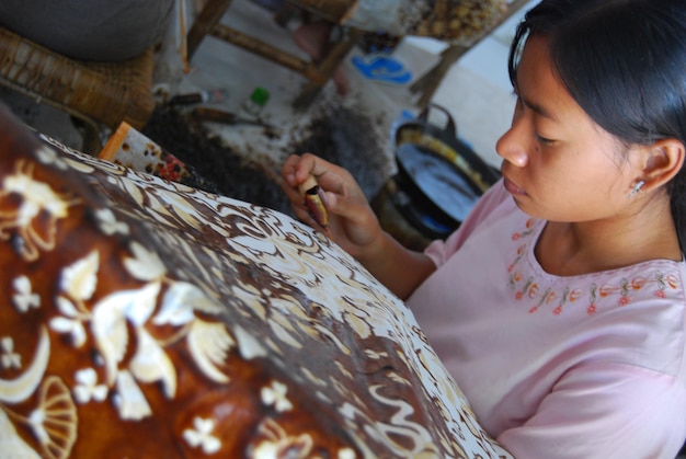Foto hochwinkelansicht einer reifen frau, die zu hause design auf batik macht