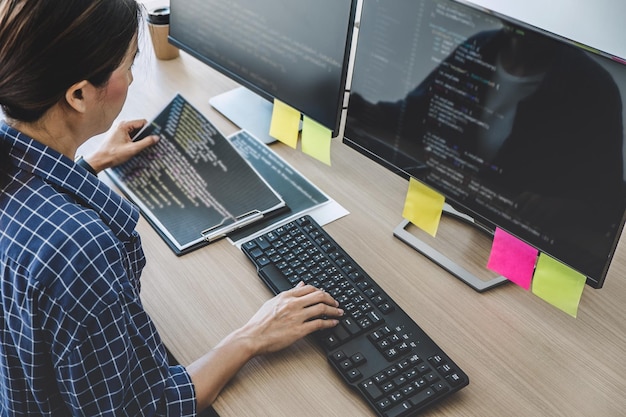 Hochwinkelansicht einer weiblichen Programmiererin, die auf Computern im Büro programmiert