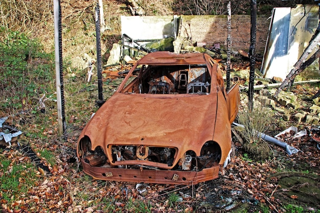 Foto hochwinkelansicht eines alten beschädigten autos auf dem feld