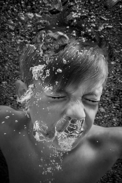 Foto hochwinkelansicht eines jungen, der im pool schwimmt