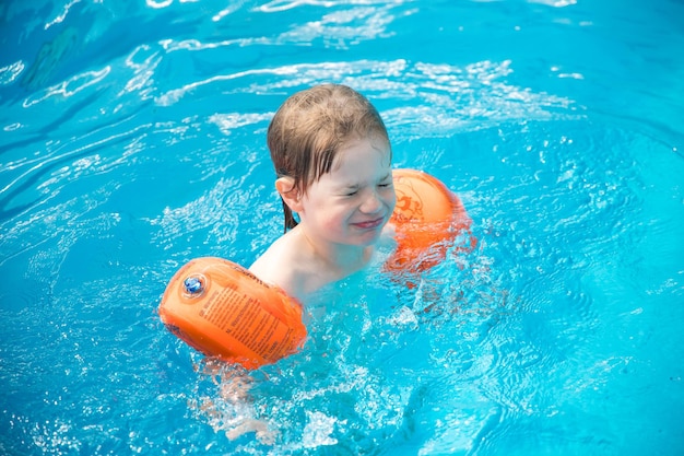 Hochwinkelansicht eines lächelnden Jungen, der im Pool schwimmt