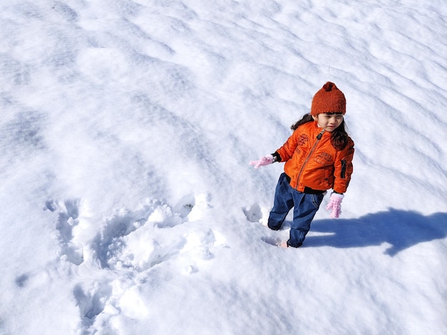 Hochwinkelansicht eines Mädchens, das auf schneebedecktem Land steht