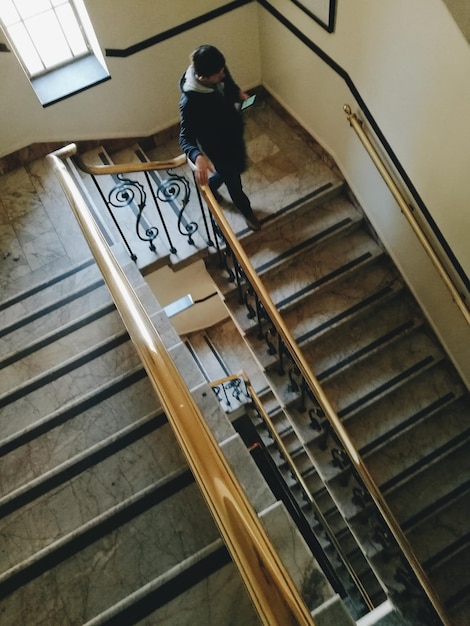 Foto hochwinkelansicht eines mannes, der auf einer treppe geht