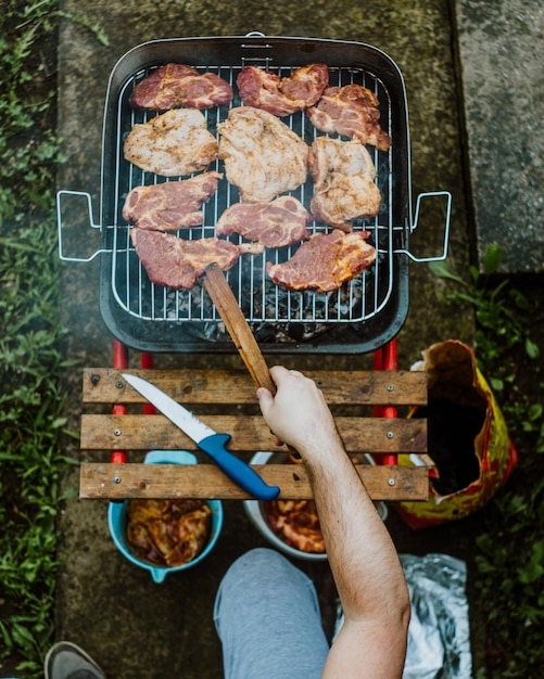 Hochwinkelansicht eines Mannes, der Essen auf dem Grill zubereitet