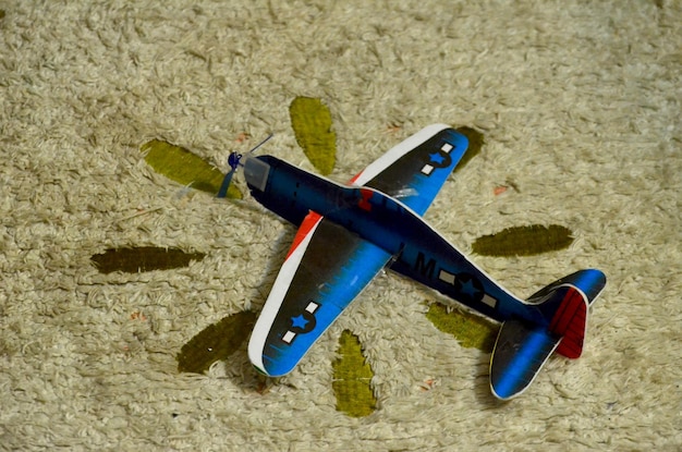 Foto hochwinkelansicht eines modellflugzeugs auf einem teppich
