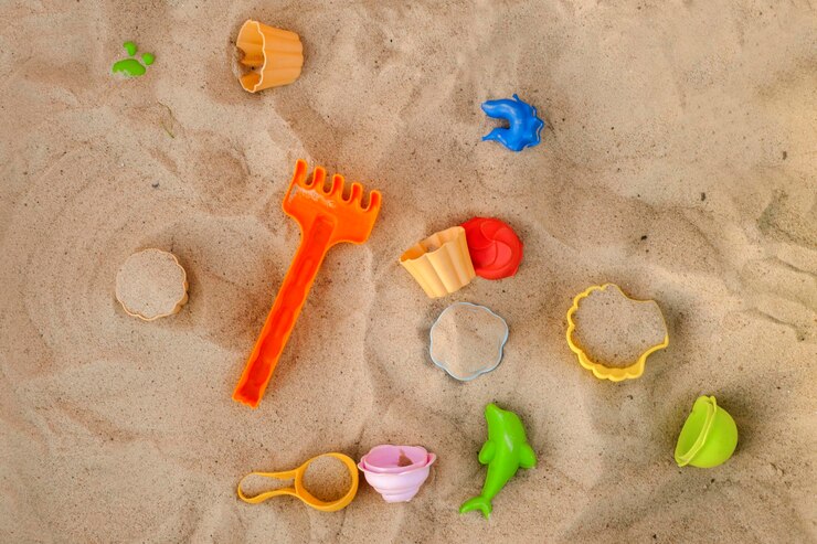 Foto hochwinkelansicht verschiedener spielzeuge auf dem sand