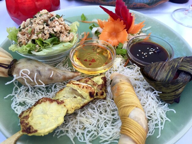 Foto hochwinkelansicht verschiedener thailändischer speisen, die auf einem teller im restaurant serviert werden