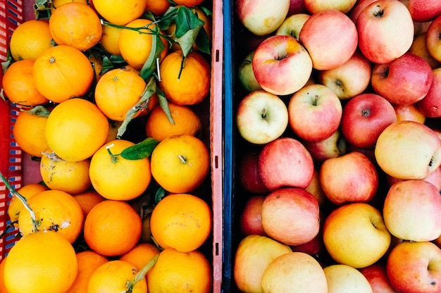 Hochwinkelansicht von Äpfeln und Orangen in Behältern auf dem Markt zum Verkauf