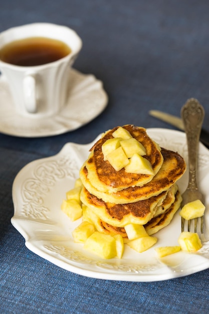 Hochwinkelansicht von Apfel-Pancake mit Tee, der auf dem Tisch serviert wird