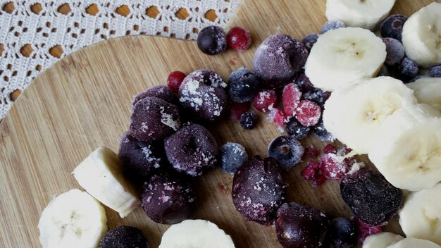 Foto hochwinkelansicht von bananenscheiben und blaubeeren auf dem tisch