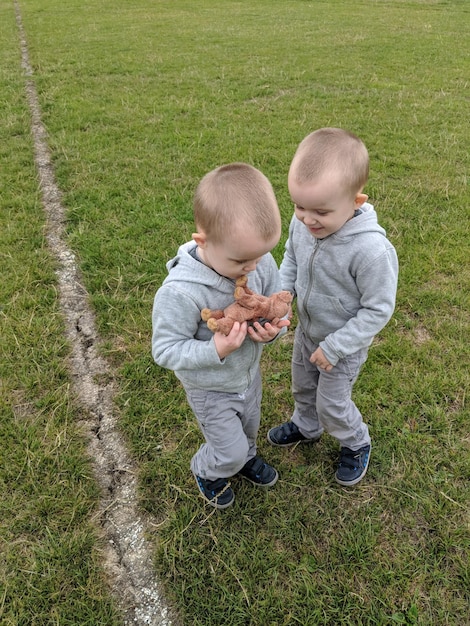 Hochwinkelansicht von Brüdern, die auf einem grasbewachsenen Feld stehen