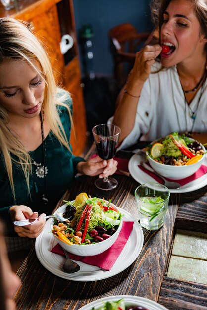 Foto hochwinkelansicht von frauen, die essen am tisch essen