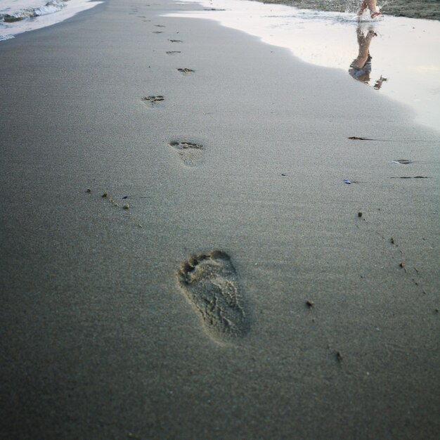 Hochwinkelansicht von Fußabdrücken am Strand