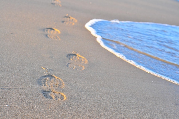 Foto hochwinkelansicht von fußabdrücken auf dem sand am strand