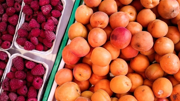 Hochwinkelansicht von Himbeeren und Aprikosen zum Verkauf auf dem Markt
