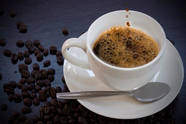 Foto hochwinkelansicht von kaffee, das in einer tasse auf dem tisch gegossen wird