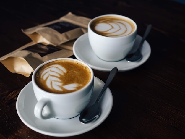 Hochwinkelansicht von Kaffee mit Schaumkunst auf dem Tisch