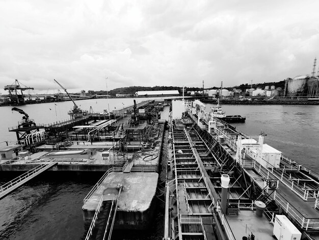 Foto hochwinkelansicht von kränen im hafen gegen den himmel