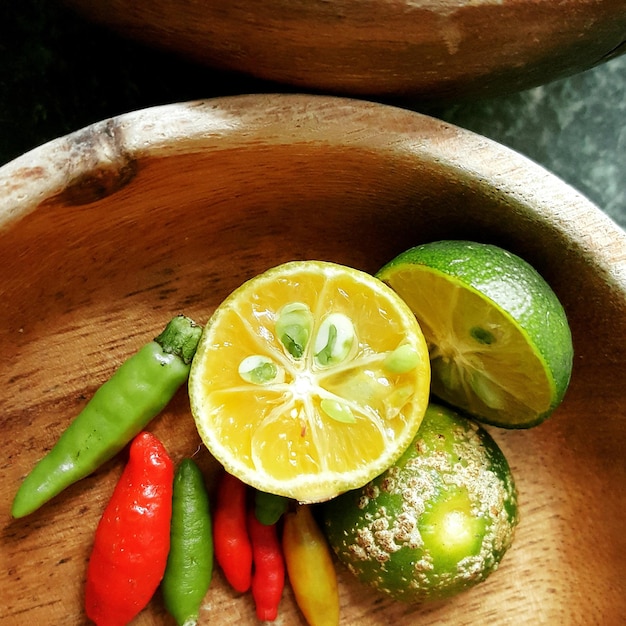 Foto hochwinkelansicht von limetten mit chili-pfeffer in einer holzschüssel