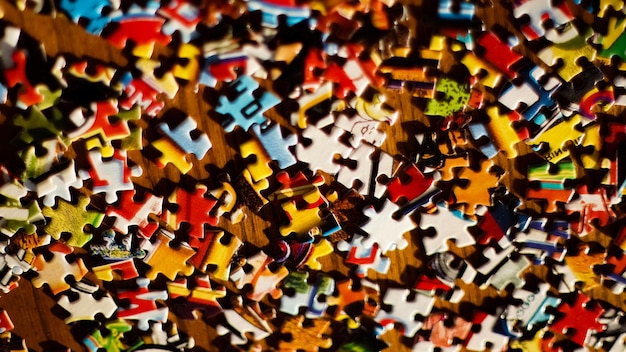 Hochwinkelansicht von mehrfarbigen Puzzle-Stücken auf dem Tisch