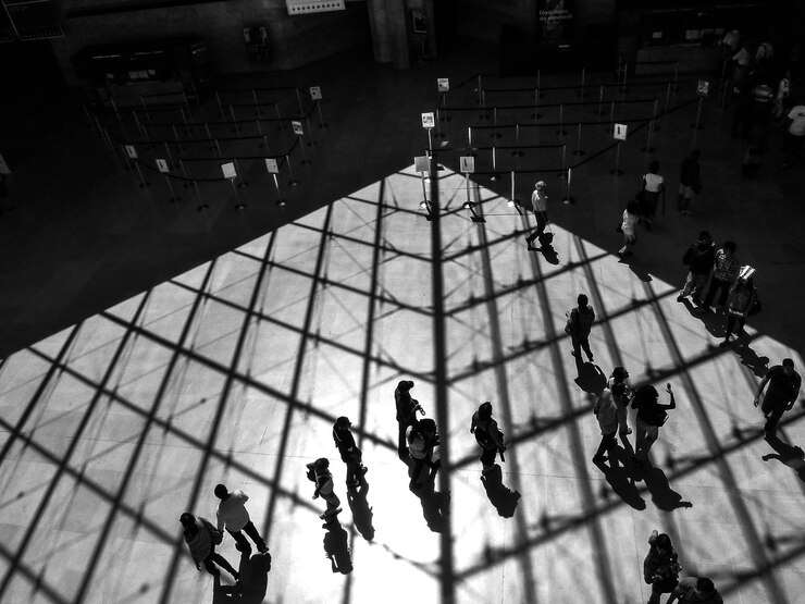 Foto hochwinkelansicht von menschen, die auf dem boden mit schatten der decke laufen