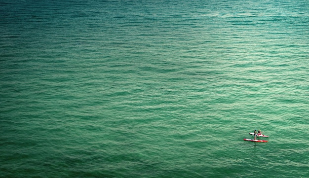 Hochwinkelansicht von Menschen, die im Meer paddeln